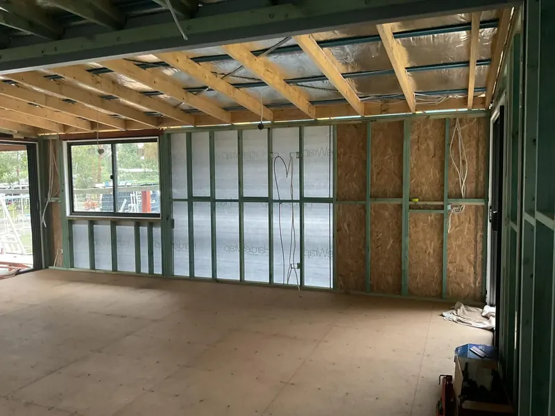 A room extension at frame stage with wiring run through the steel studs