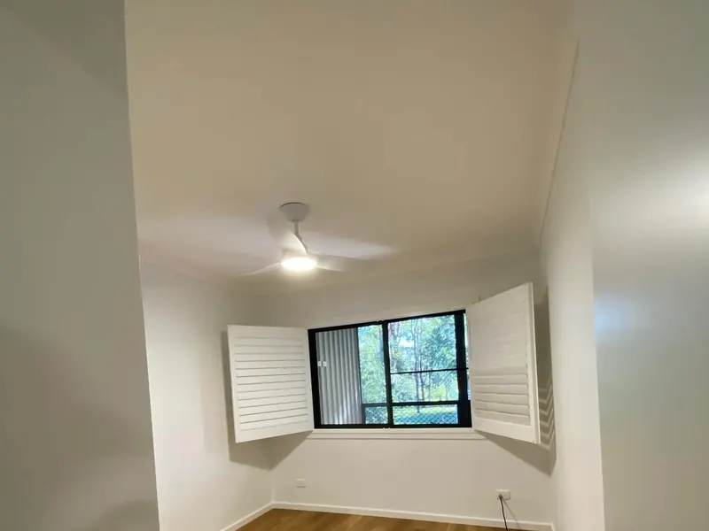 A ceiling fan installed in a finished bedroom with timber flooring